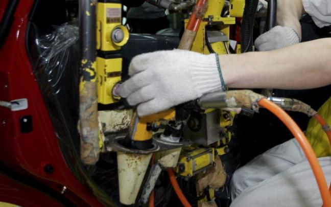Un trabajador realiza una inspección de la puerta de un vehículo en una cadena de ensamblaje