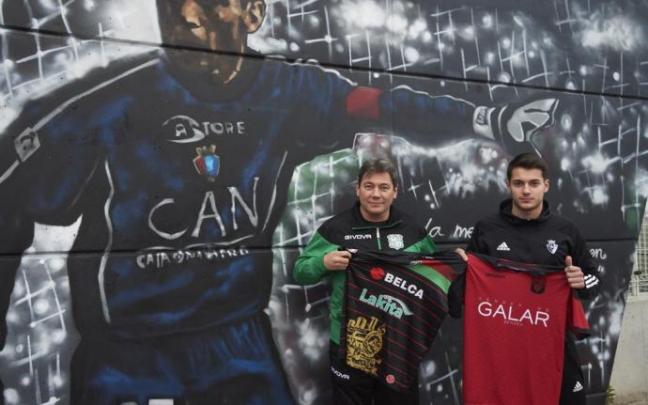 Elías y Migue Tomé sujetan las camisetas de sus equipos junto al mural de Juan Carlos Unzué en el campo del Orcoyen.