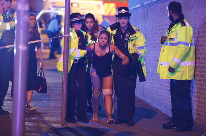 Policías ayudan a una joven herida en las cercanías del Manchester Arena, el 22 de mayo de 2017.