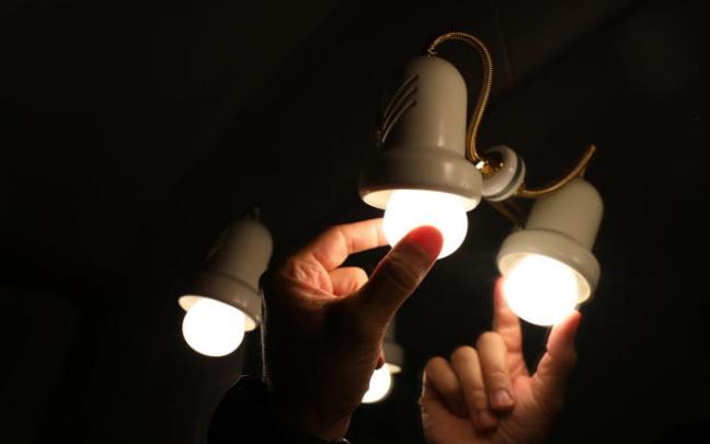 Una persona cambia la bombilla de una lampara.