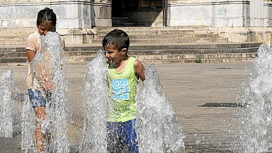 Dos niños juegan en una fuente junto a la Catedral Nueva de Vitoria-Gasteiz. Es una escena típica durante los presentes días de ola de calor en la capital alavesa.