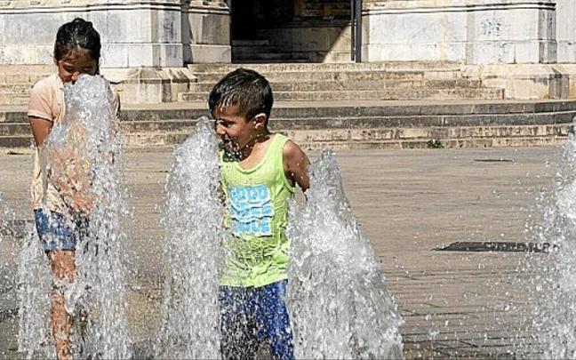 Dos ni&ntilde;os juegan en una fuente junto a la Catedral Nueva de Vitoria-Gasteiz. Es una escena t&iacute;pica durante los presentes d&iacute;as de ola de calor en la capital alavesa.