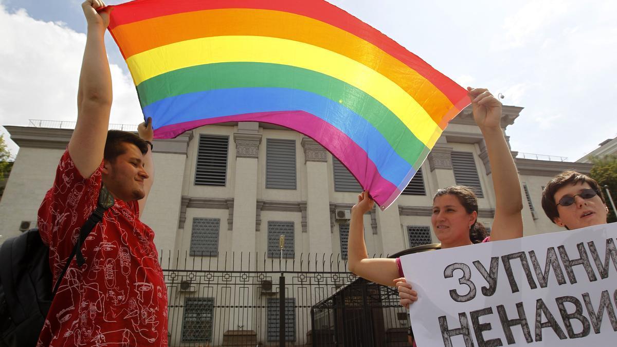 Activistas LGBTIQ+ sostienen una bandera durante una protesta frente a la Embajada de Rusia en Kiev, Ucrania.