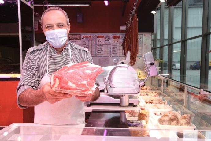 Un carnicero muestra su producto en una carnicería de Vitoria.