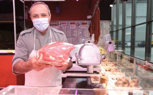 Un carnicero muestra su producto en una carnicería de Vitoria.