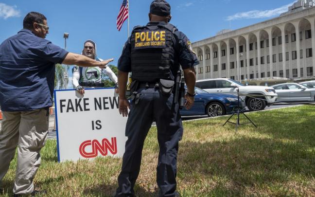 Un policía y un manifestante pro-Trump ante la Corte de Florida Un policía y un manifestante pro-Trump ante la Corte de Florida