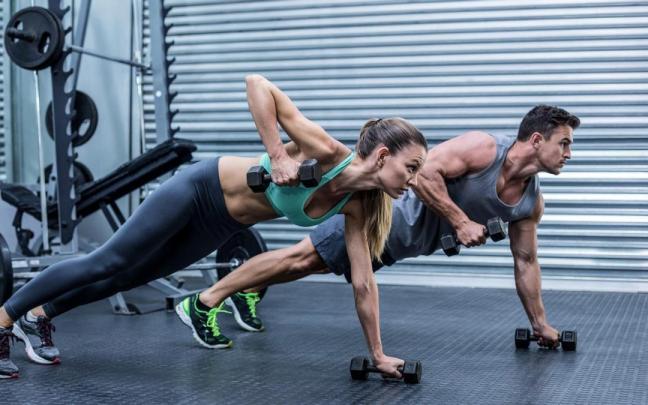 Una pareja practica ejercicio en un gimnasio.