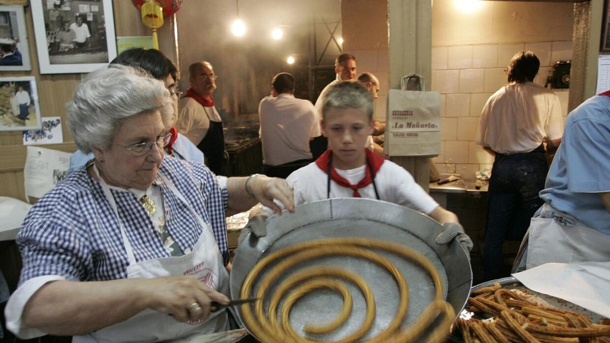 11 de julio de 2007, Paulina saca una bandeja de churros ayudada por uno de sus nietos.