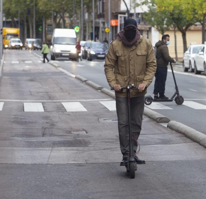 Dos usuarios de patinete circulan por el centro de Gasteiz.