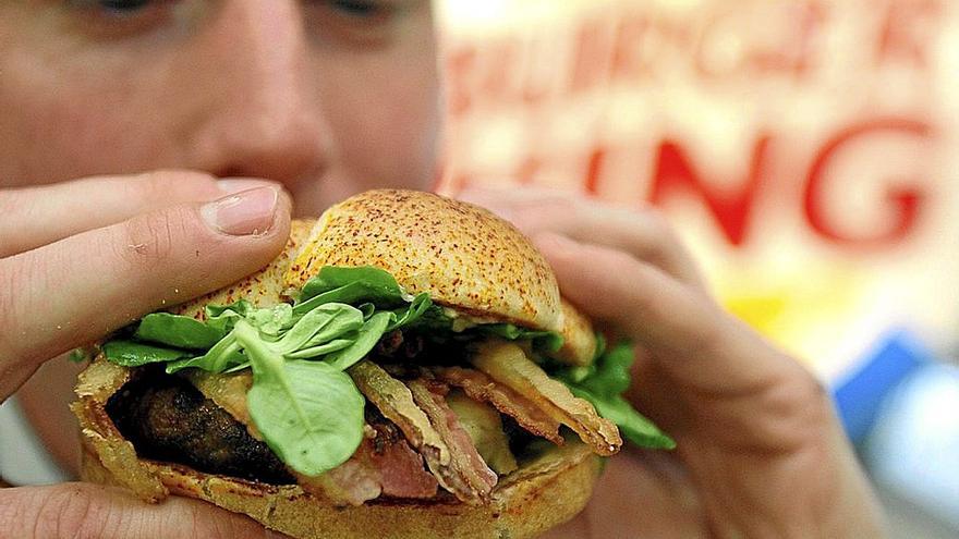 Un adolescente a punto de comerse una hamburguesa. | FOTO: E.PRESS