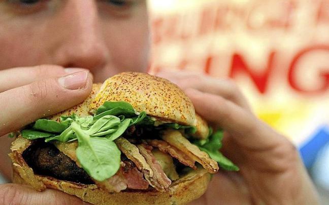 Un adolescente a punto de comerse una hamburguesa. | FOTO: E.PRESS
