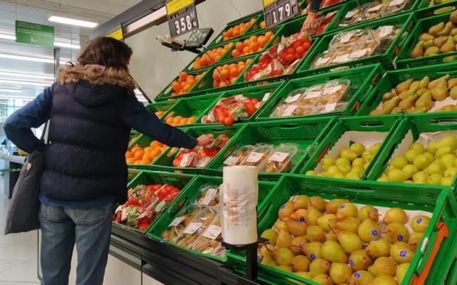 Una mujer escoge fruta en un supermercado. Una mujer escoge fruta en un supermercado.