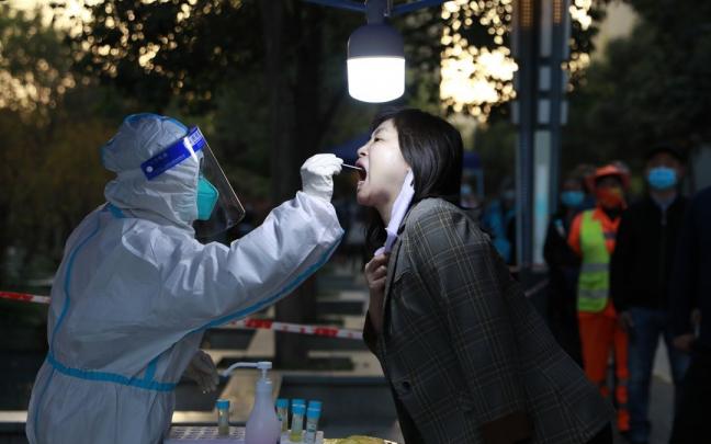 Un sanitario realiza una PCR a una mujer en Baqiao.