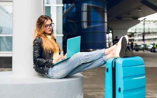 Una joven con su maleta espera para embarcar en el aeropuerto.