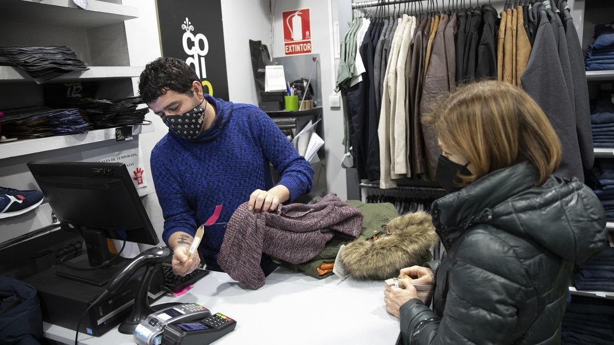 Clientes comprando ropa en las rebajas de invierno.