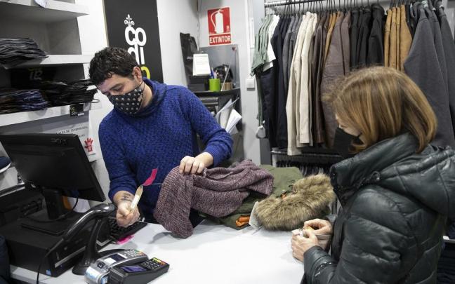 Clientes comprando ropa en las rebajas de invierno.