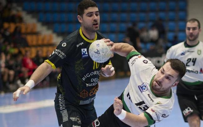 Aitor García, escorado, trata de lanzar en el partido ante el Cangas.