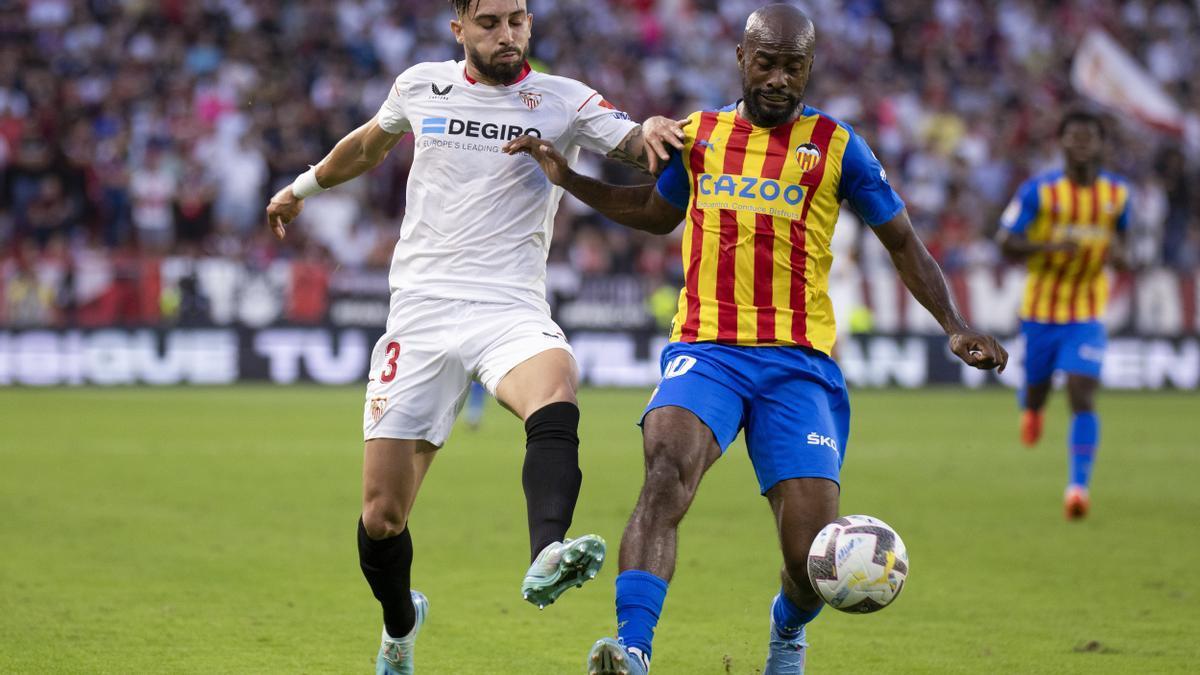 Dimitri Foulquier y Alex Telles pelean por un balón.