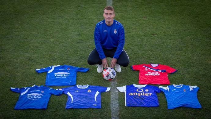 Fermín Úriz posa junto con las camisetas de los seis ascensos a Segunda División B con la Peña Sport. La de arriba a la izquierda, la camiseta de su debut con los de Tafalla.