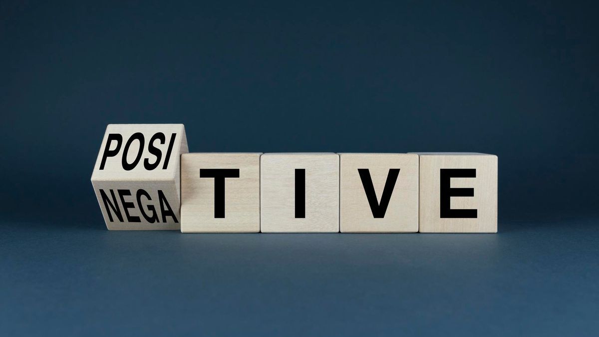 Cubos de madera en los que se puede leer positivo y negativo en inglés.