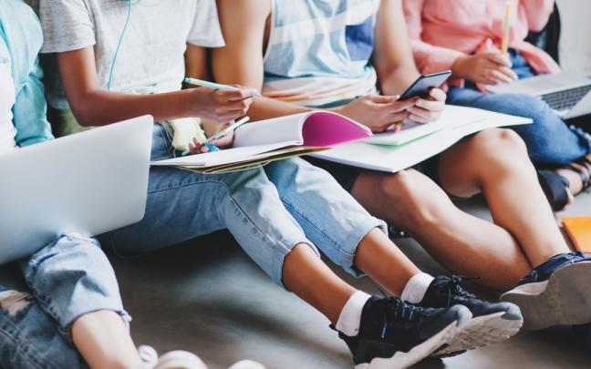 Varios j&oacute;venes toman apuntes.