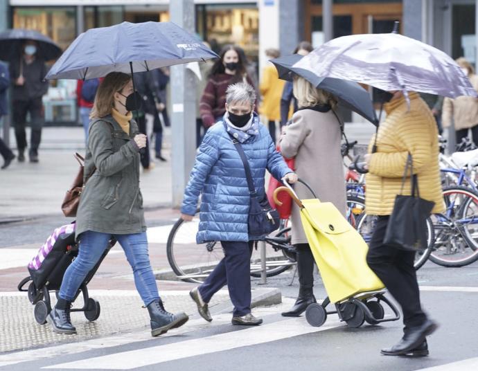 Personas caminan por la calle con paraguas para protegerse de la lluvia