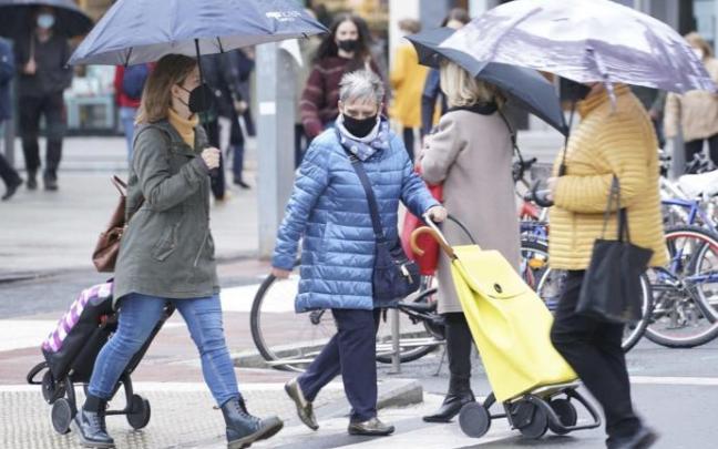 Personas caminan por la calle con paraguas para protegerse de la lluvia