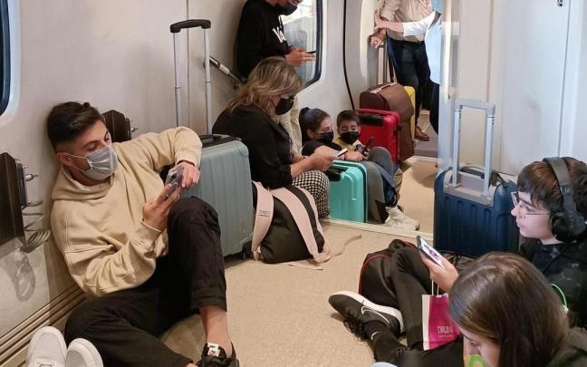 Pasajeros extreme&ntilde;os sentados en el suelo tras la incidencia del tren Alvia el 1 de noviembre.