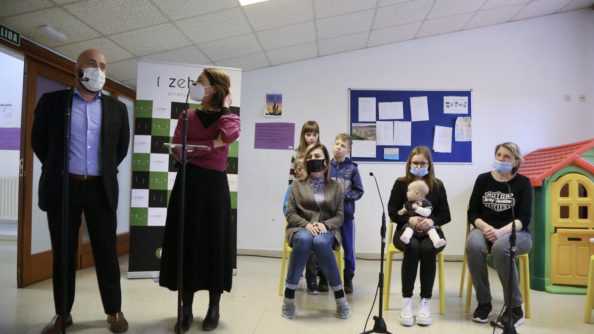 Xabier Legarreta, director de Migración y Asilo del Gobierno Vasco, y Arantza Chacón, directora de Zehar Errefuxuaruekin, junto a dos familias de refugiados ucranianos.