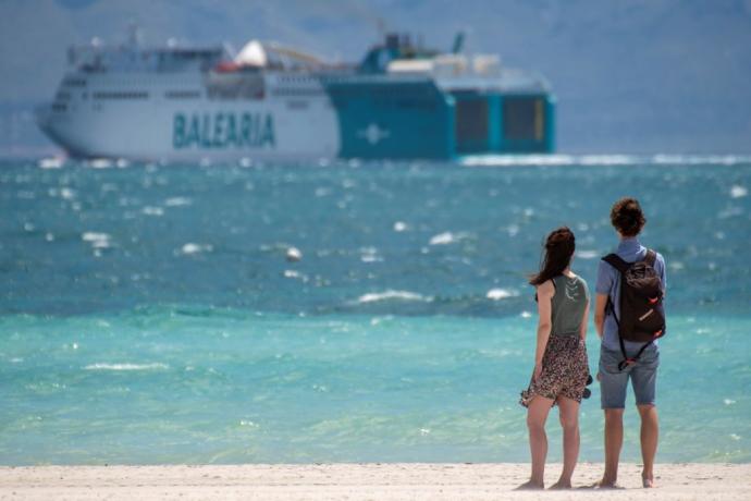 Una pareja pasea por la playa de Alcudia en Palma de Mallorca.