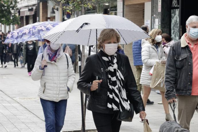 Una persona camina aferrada a su paraguas en Vitoria..