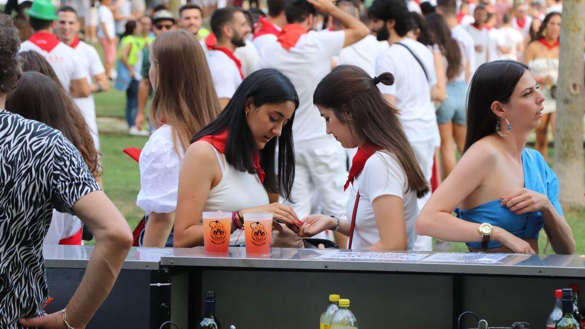 Dos jóvenes hacen cuentas durante las fiestas de Tudela de este año.