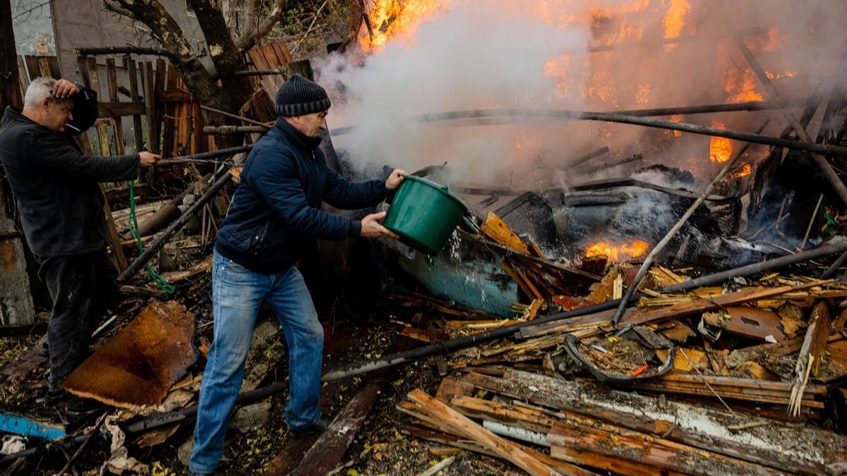 Dos hombres intentan sofocar el fuego tras un ataque en Bakhmut (Donetsk).