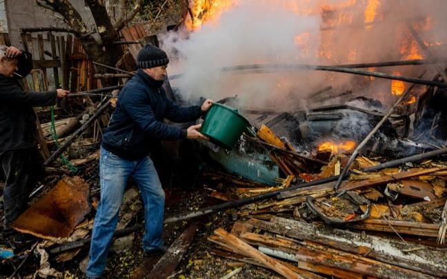 Dos hombres intentan sofocar el fuego tras un ataque en Bakhmut (Donetsk).