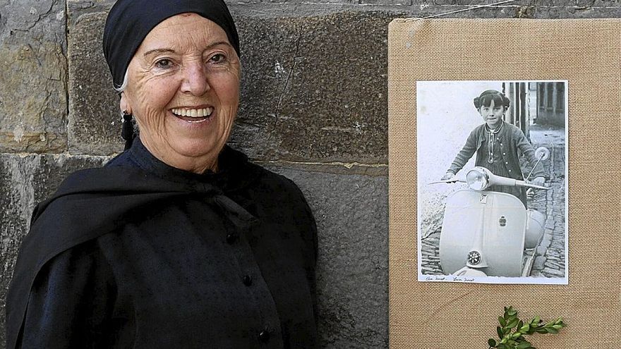 María Luisa Sancet, vecina de Otsagabia posa junto a una foto de su infancia.