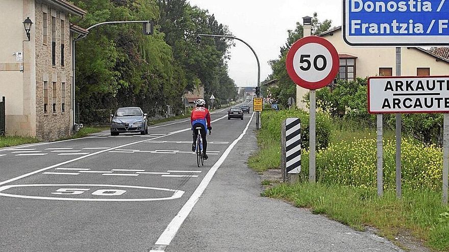 Vehículos y ciclista circulan por la carretera N - 104.