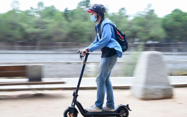 Un hombre pasea con un patinete eléctrico. Un hombre pasea con un patinete eléctrico.