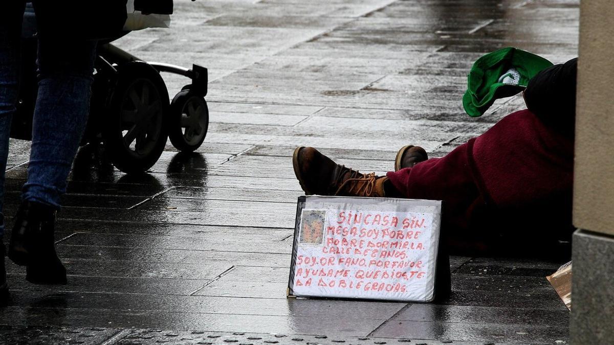 Una persona pide limosna en la avenida Carlos III de Pamplona.