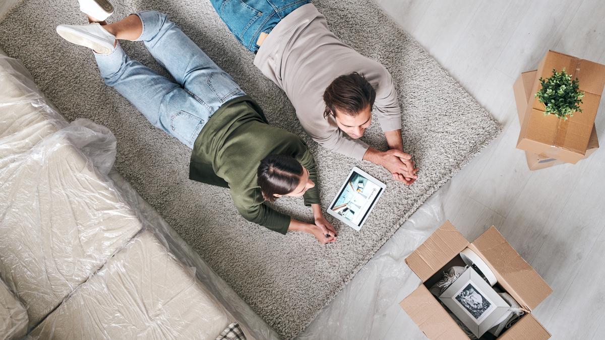 Una pareja lee en su tableta un anuncio de una inmobiliaria.