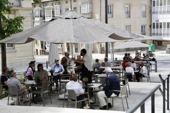 Personas sentadas en la terraza de un bar.