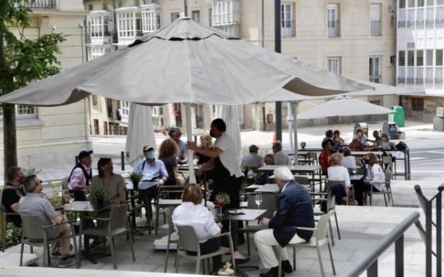 Personas sentadas en la terraza de un bar.