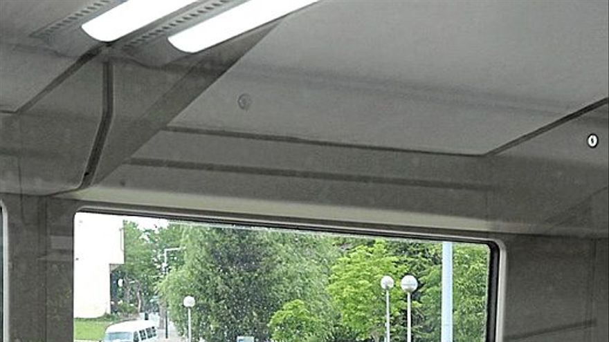 Pasajeros en el tranv&iacute;a con un autob&uacute;s de Tuvisa al fondo.