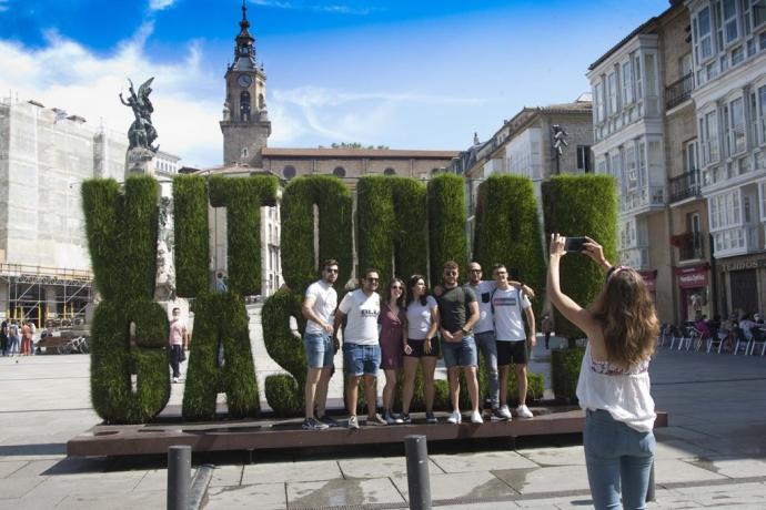 Turistas haciéndose una foto junto a la escultura vegetal de Vitoria