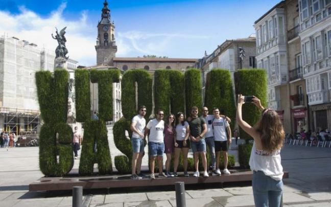 Turistas haciéndose una foto junto a la escultura vegetal de Vitoria