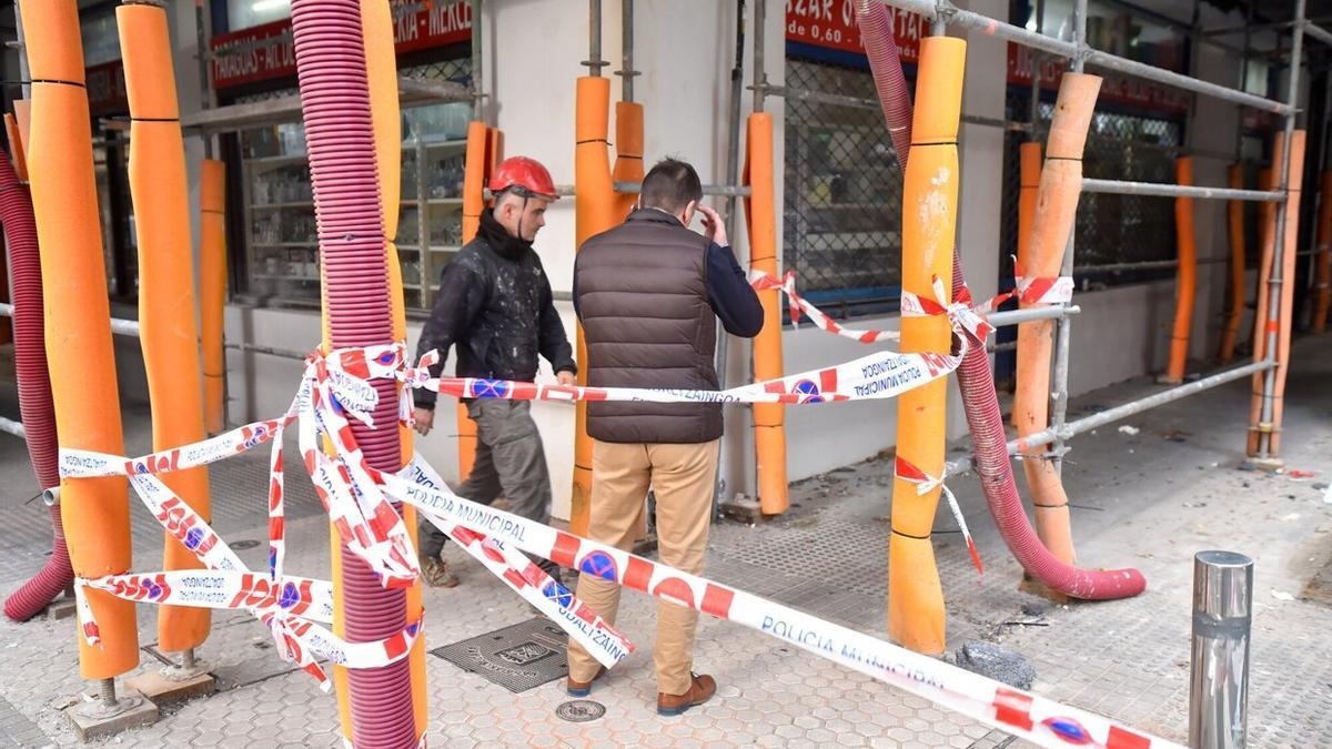 Un obrero y un vecino, junto al portal afectado.