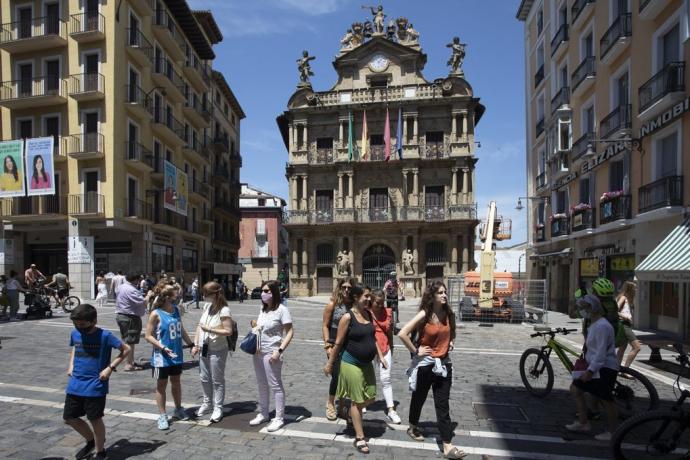 Personas paseando por delante del ayuntamiento de Pamplona.