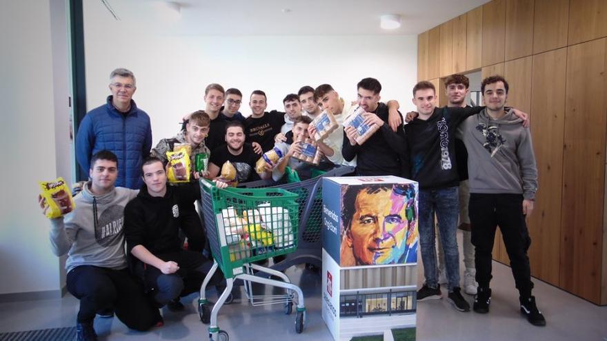 Jóvenes de Salesianos junto a parte de los alimentos recogidos.