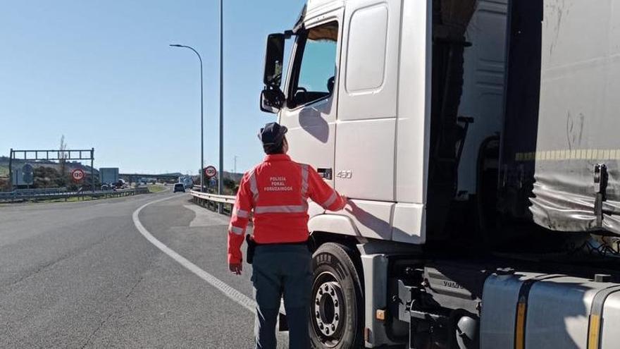 Un agente de Policía Foral, junto al camión inmovilizado.