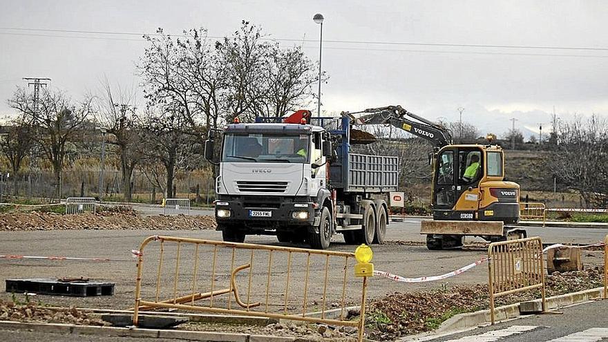 Una excavadora y un camion, en el inicio de las obras del parking de autocaravanas.