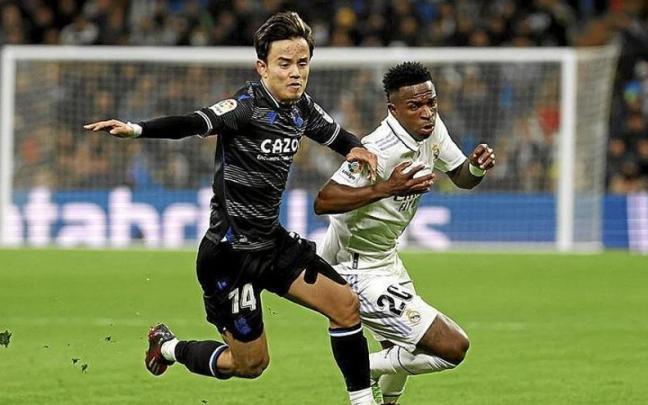 Take Kubo, intentando evitar un avance de Vinicius.